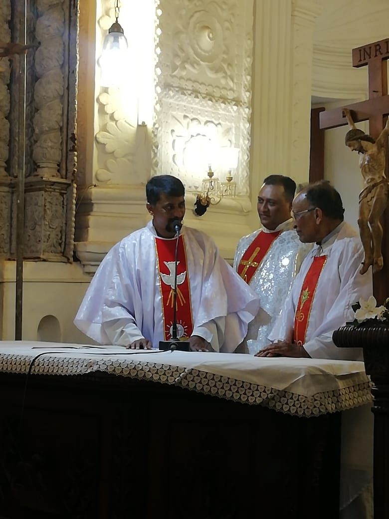 The incoming and outgoing parish priests interacting