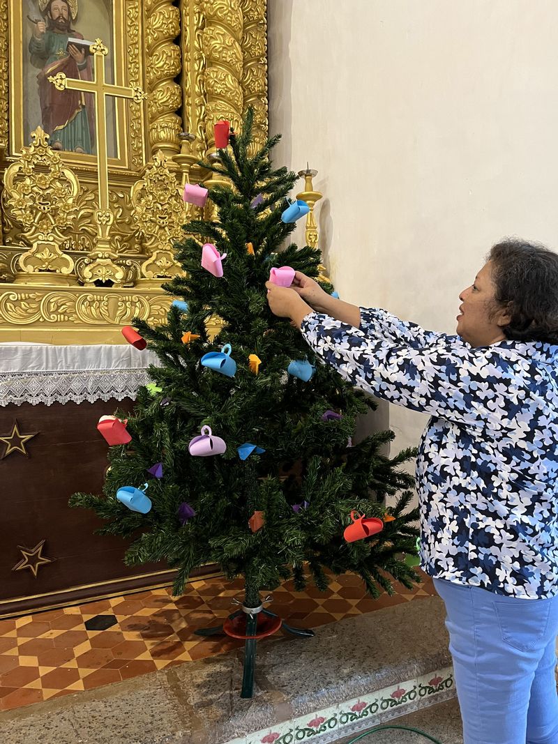 A Parishioner from Chicalim picking up a tag from The Giving Tree